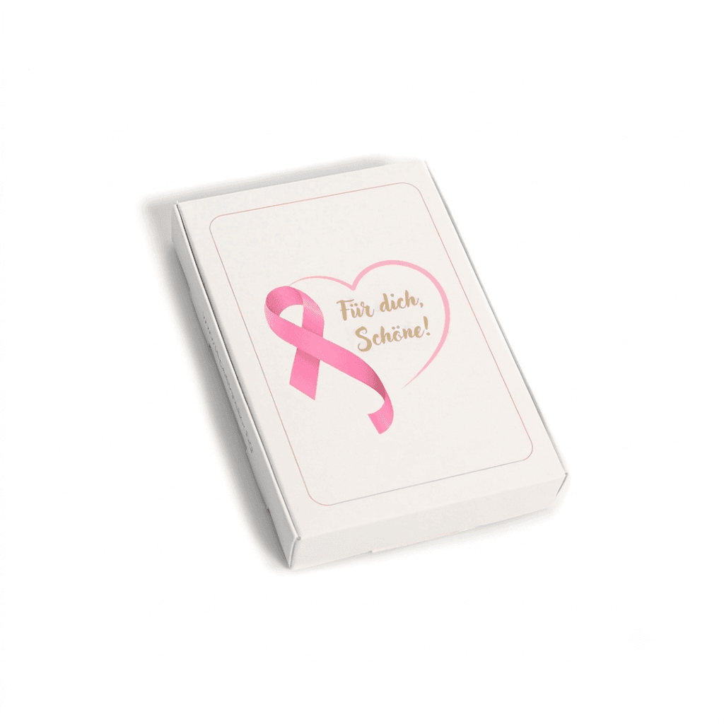 Weiße Geschenkbox mit rosa Brustkrebs-Schleife, Herz und dem goldenen Schriftzug „Für dich, Schöne!“.