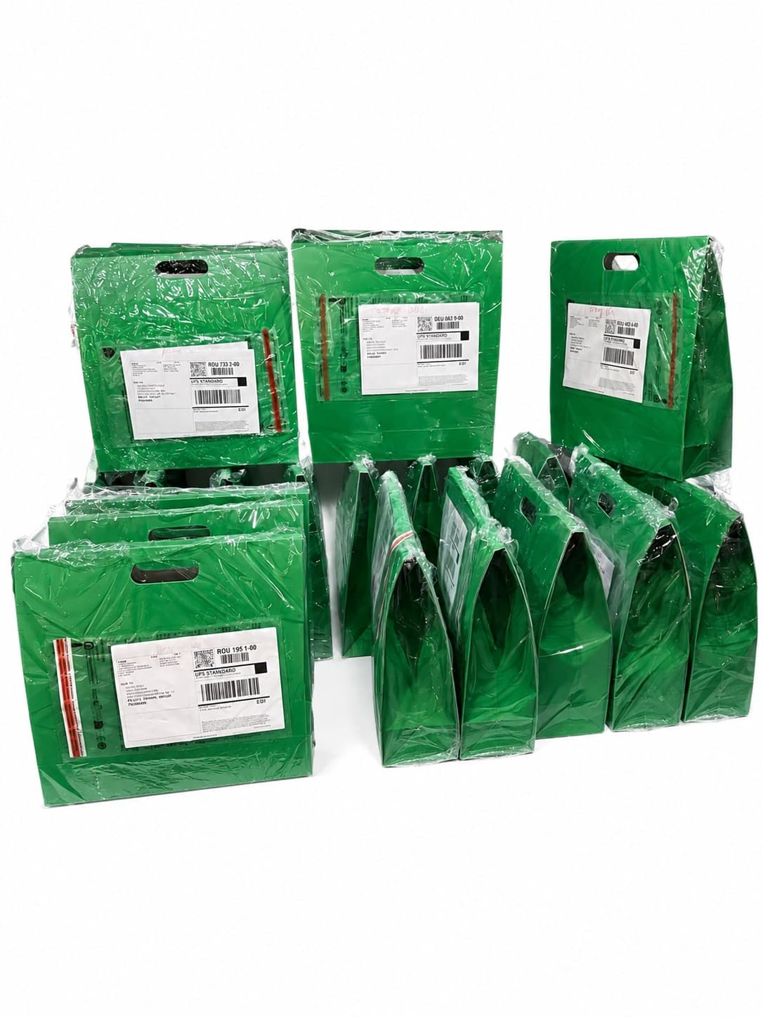 Mehrere grüne Versandtaschen mit UPS-Etiketten sind ordentlich in Reihen auf weißem Hintergrund angeordnet.